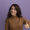 smiling young beautiful girl wearing brown turtleneck sweater showing thumb up isolated on purple background